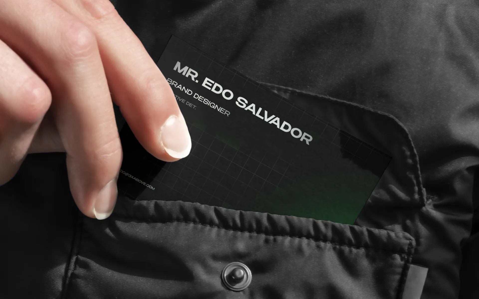 A hand pulling a black 3X Above business card from a jacket pocket