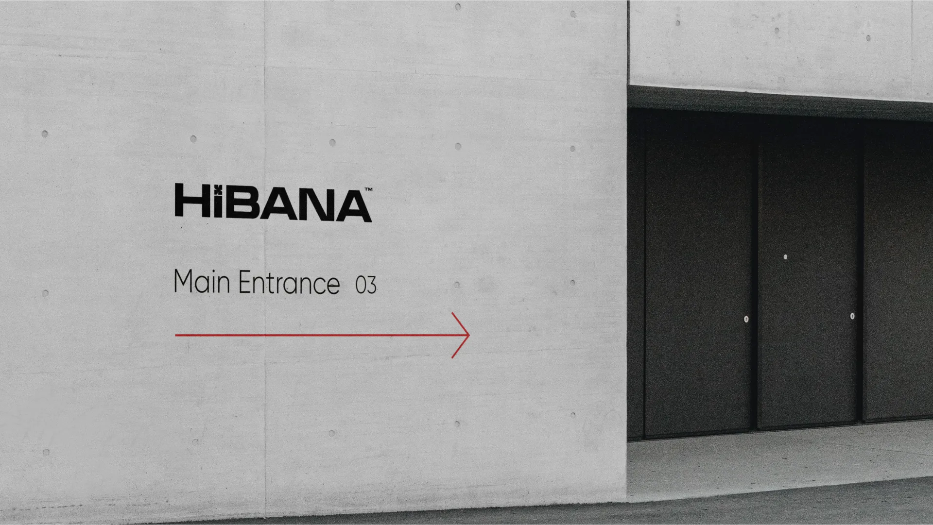 Hibana main entrance wayfinding painted on a concrete wall with a red arrow